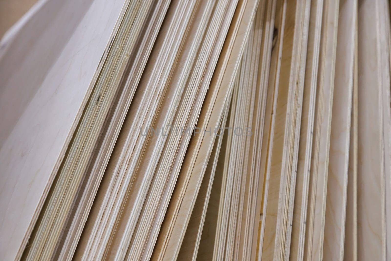 stack of vertical standing leaning plywood sheets in warehouse.
