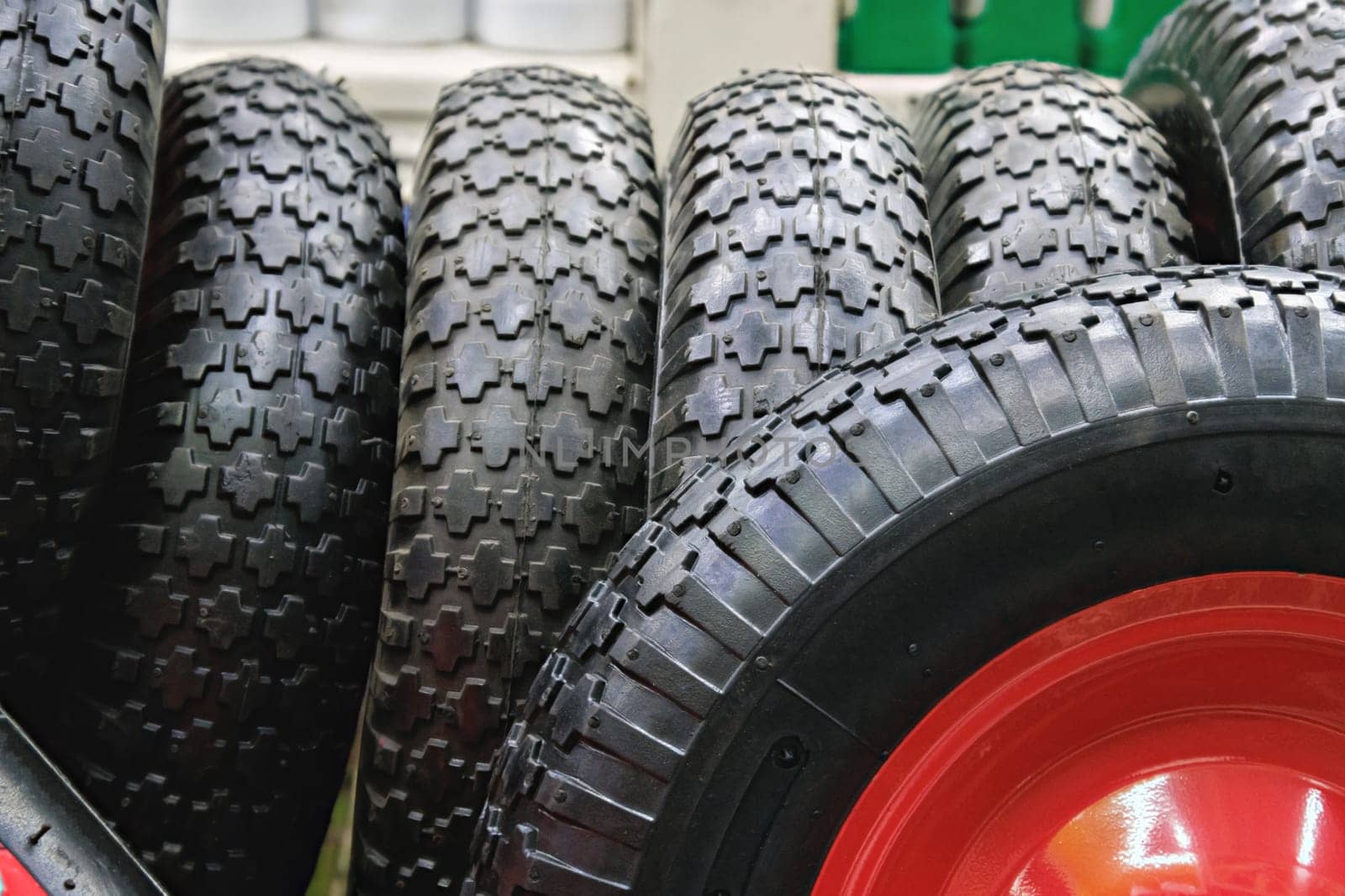 black rubber barrow wheels with grippy tread surface, closeup with selective focus