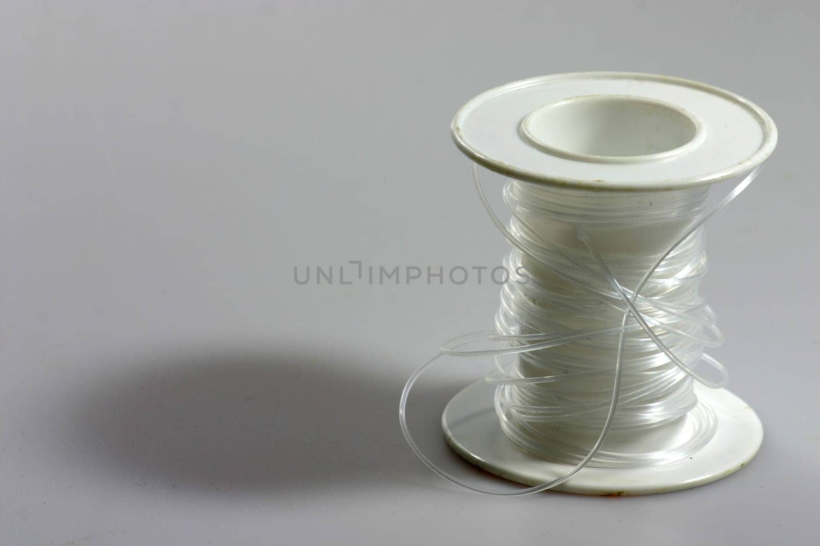 Clear thread on white plastic roll