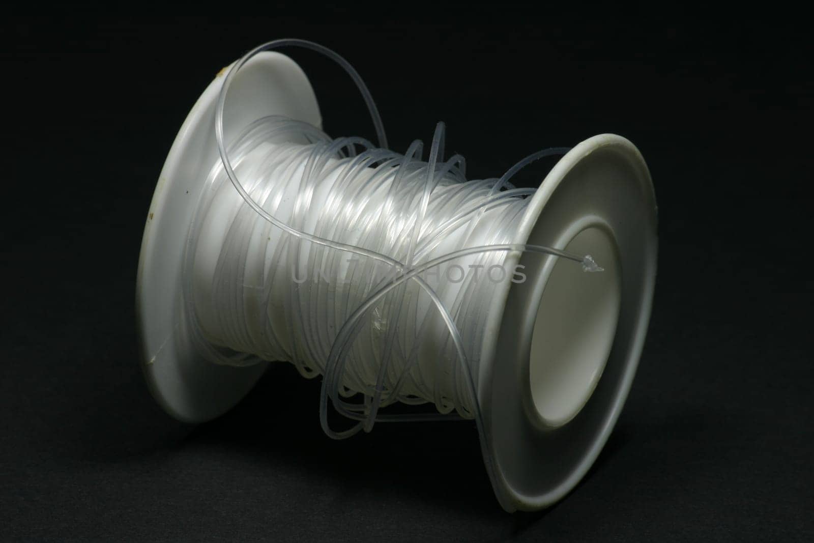 Clear thread on white plastic roll