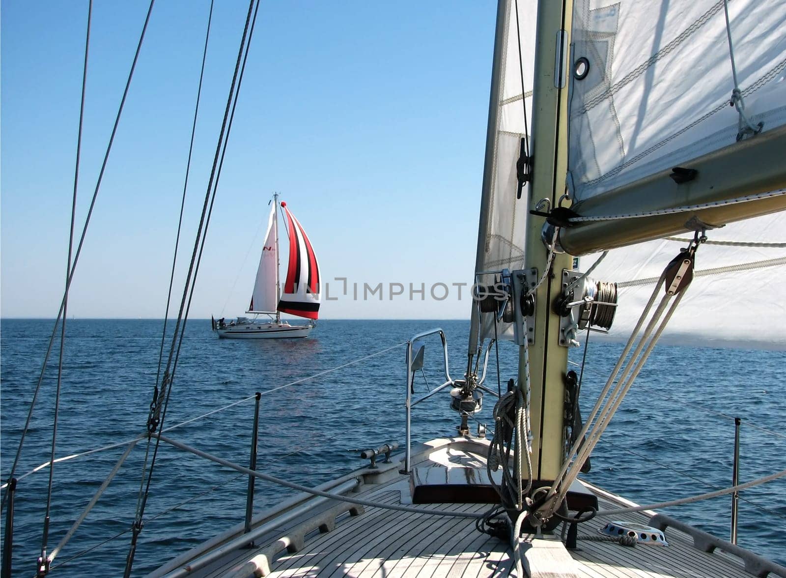 Windward gives way to leeward,according to the right-of-way rule when sailing. The windward boat (with colorful sails) gives way to the leeward boat. In this case,it fits and both can continue to steer the course.