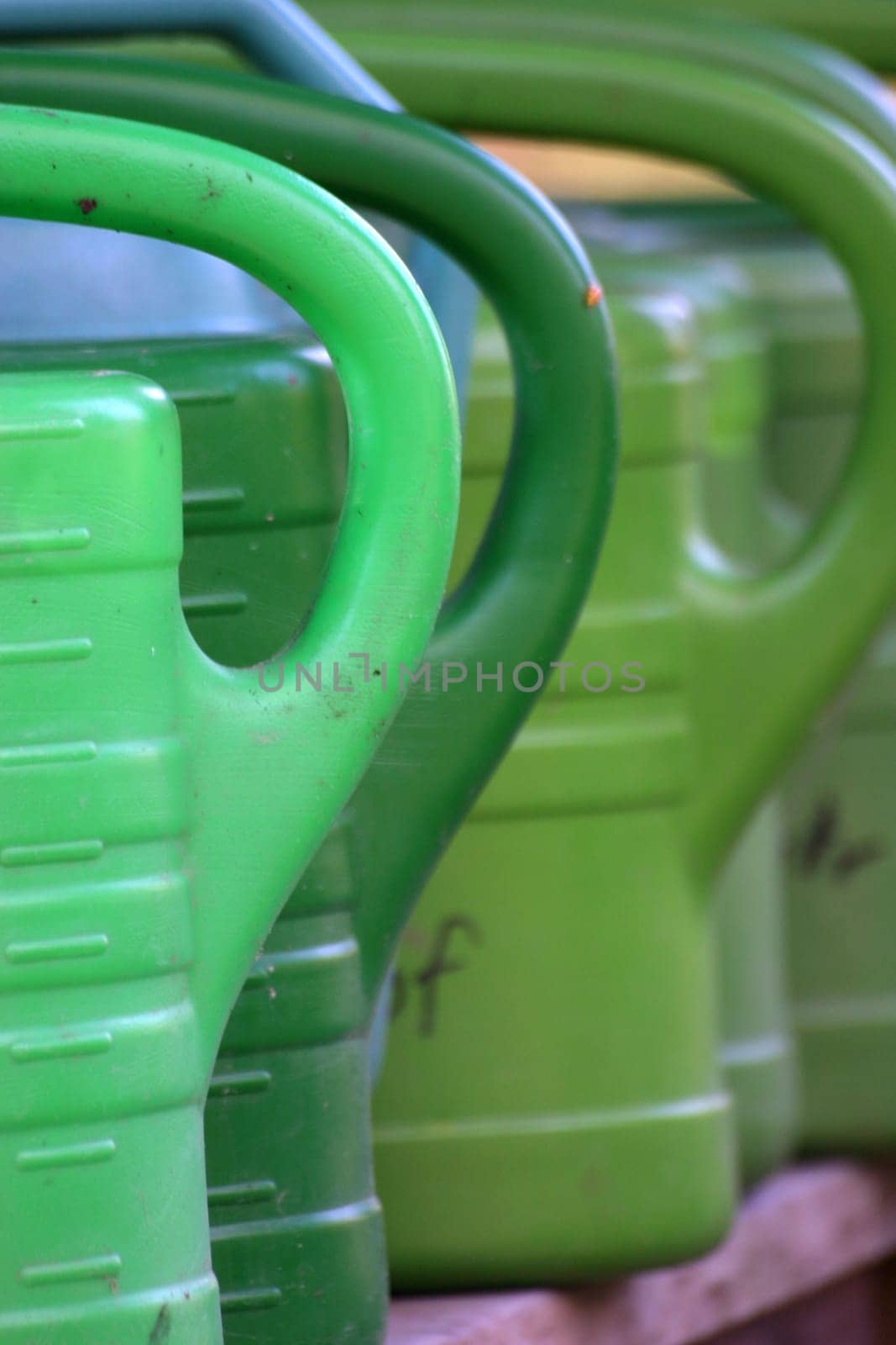 Green watering cans in a cemetery