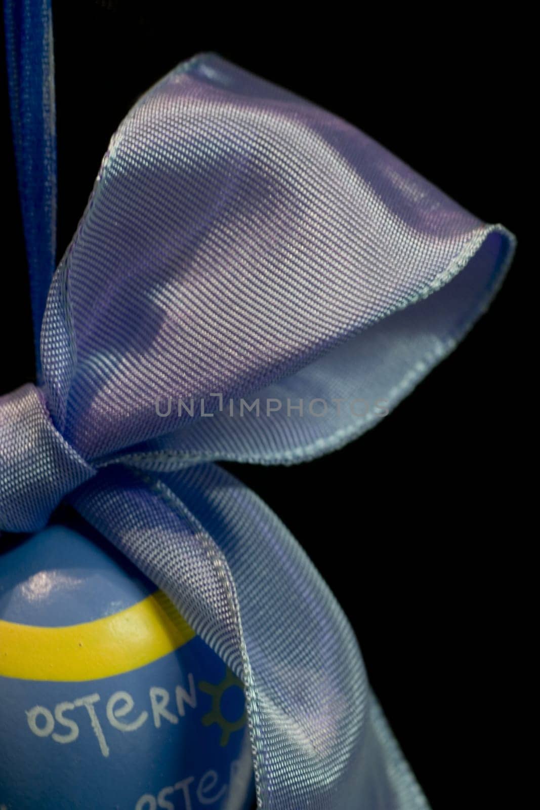 Easter egg with bow,cut on the left,against a black background