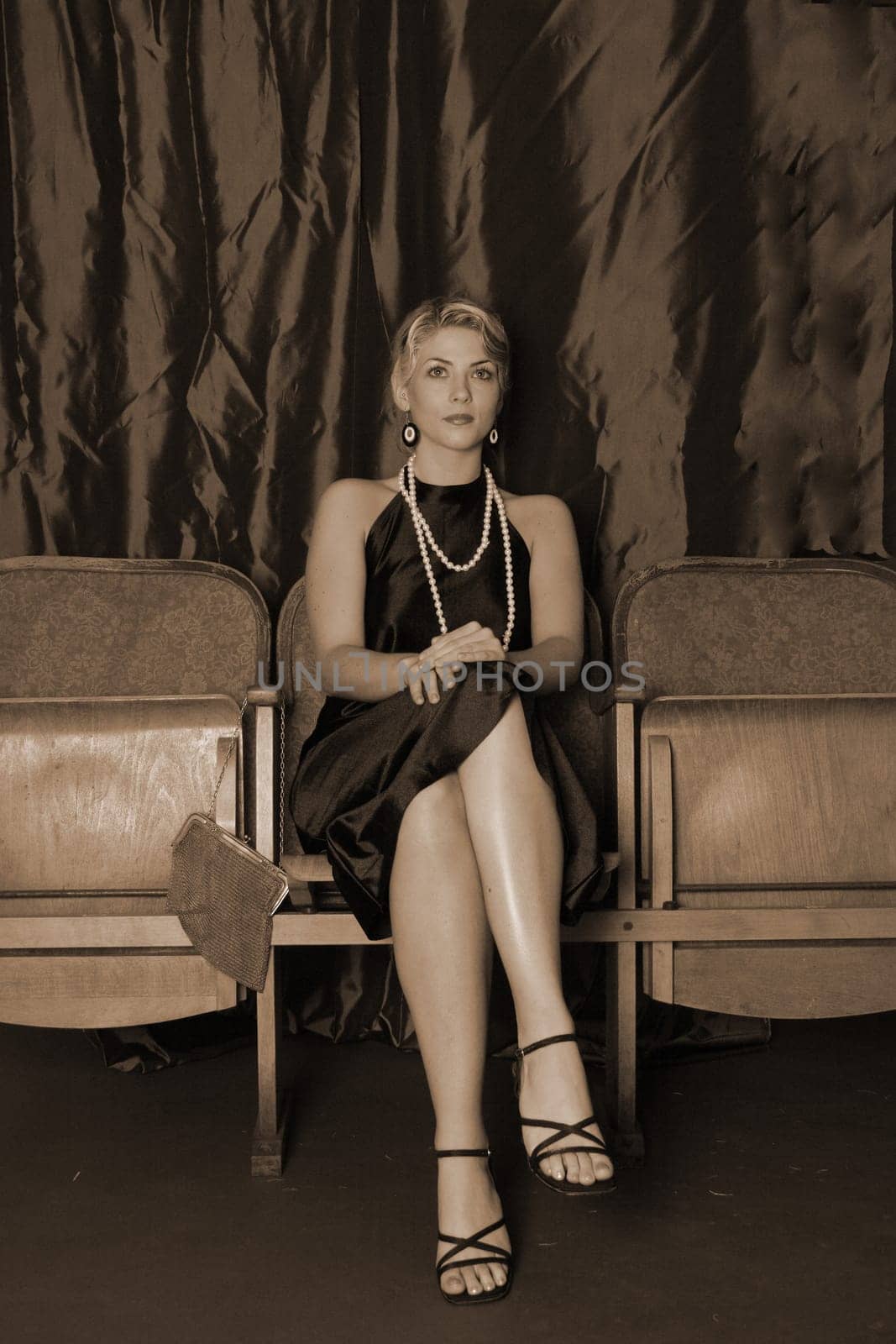 A woman in the style of the 20s sits stiffly in the cinema