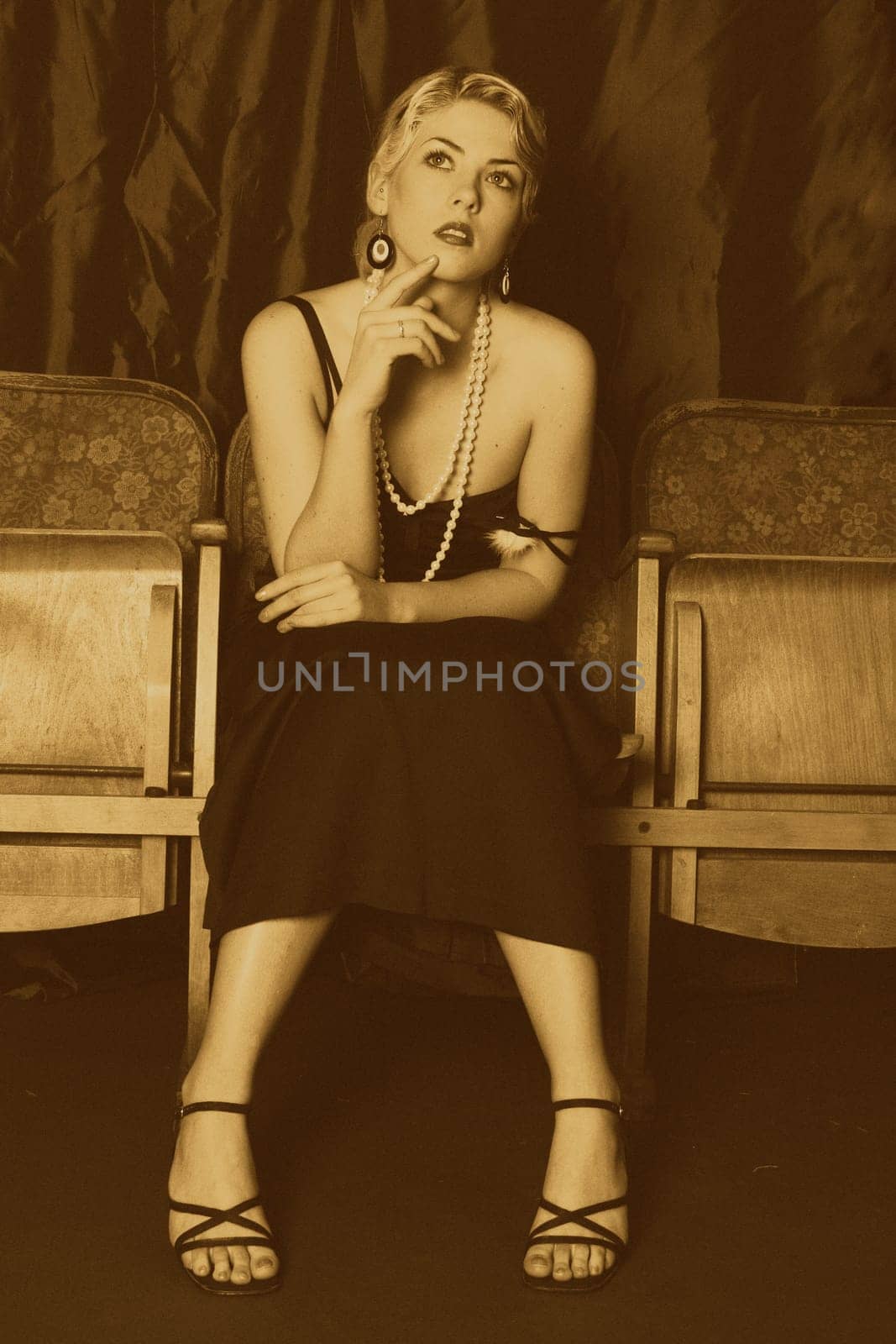 A woman in the style of the 20s sits thoughtfully in the cinema