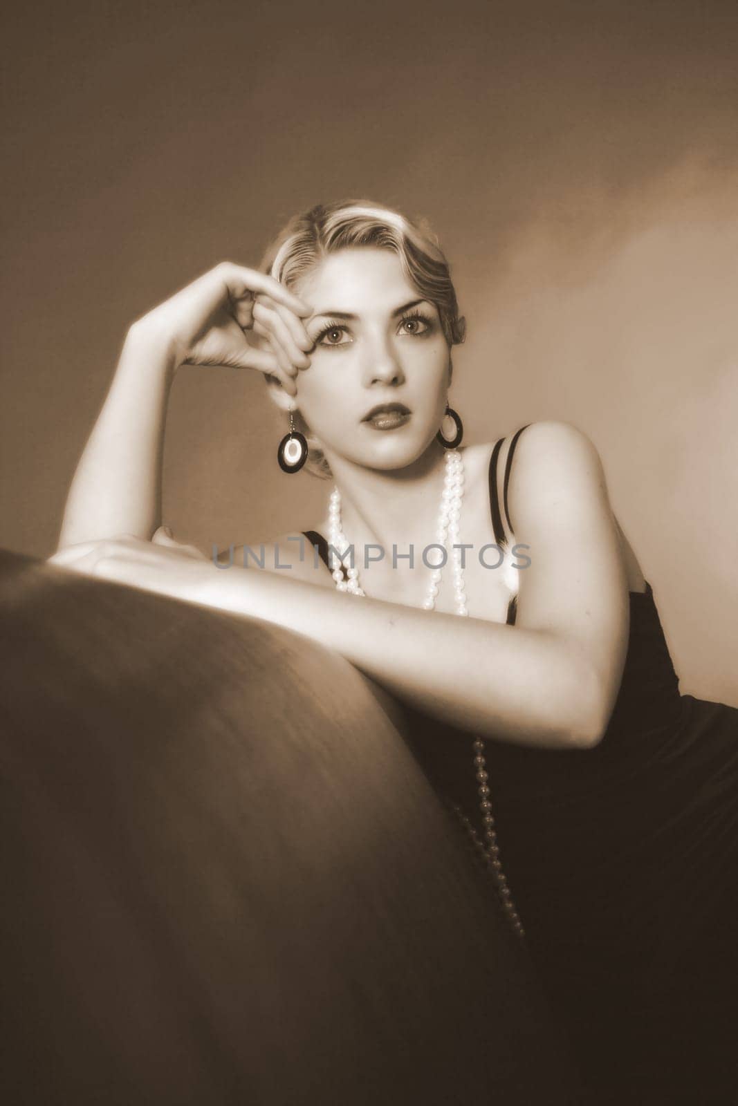 Portrait photo of a woman dressed in the style of the 20s,sitting on a leather sofa