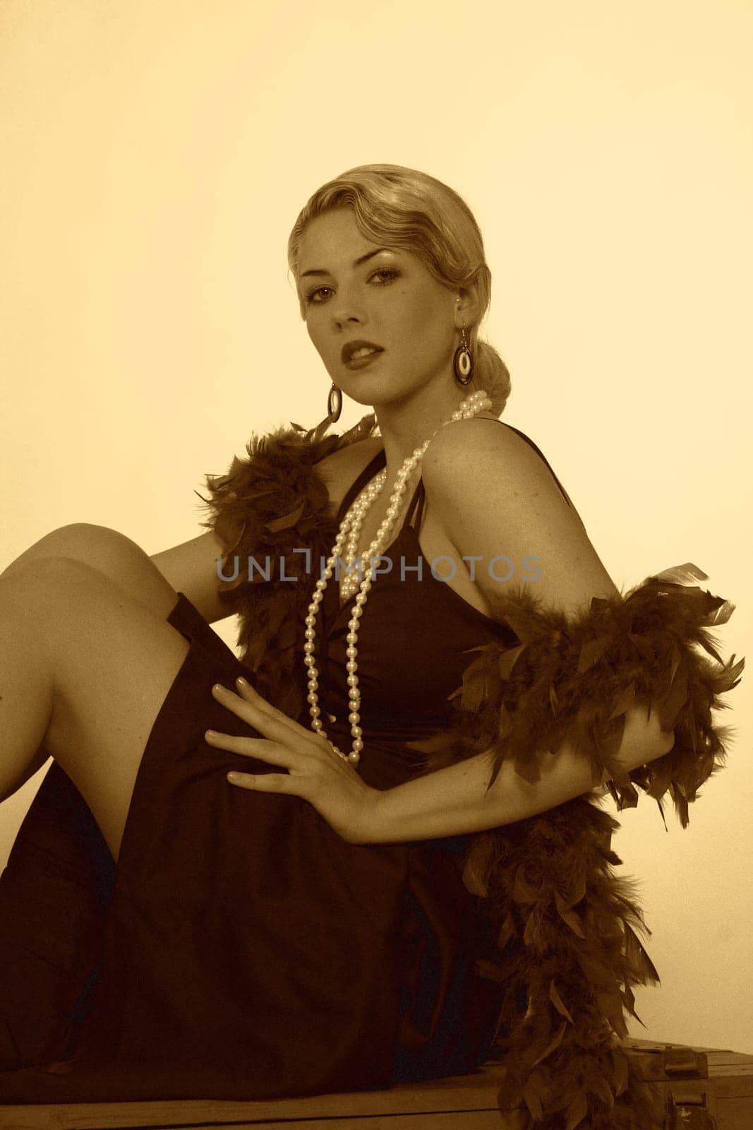 A woman in the style of the 20s sits on an ammunition box and looks at the camera with a smile