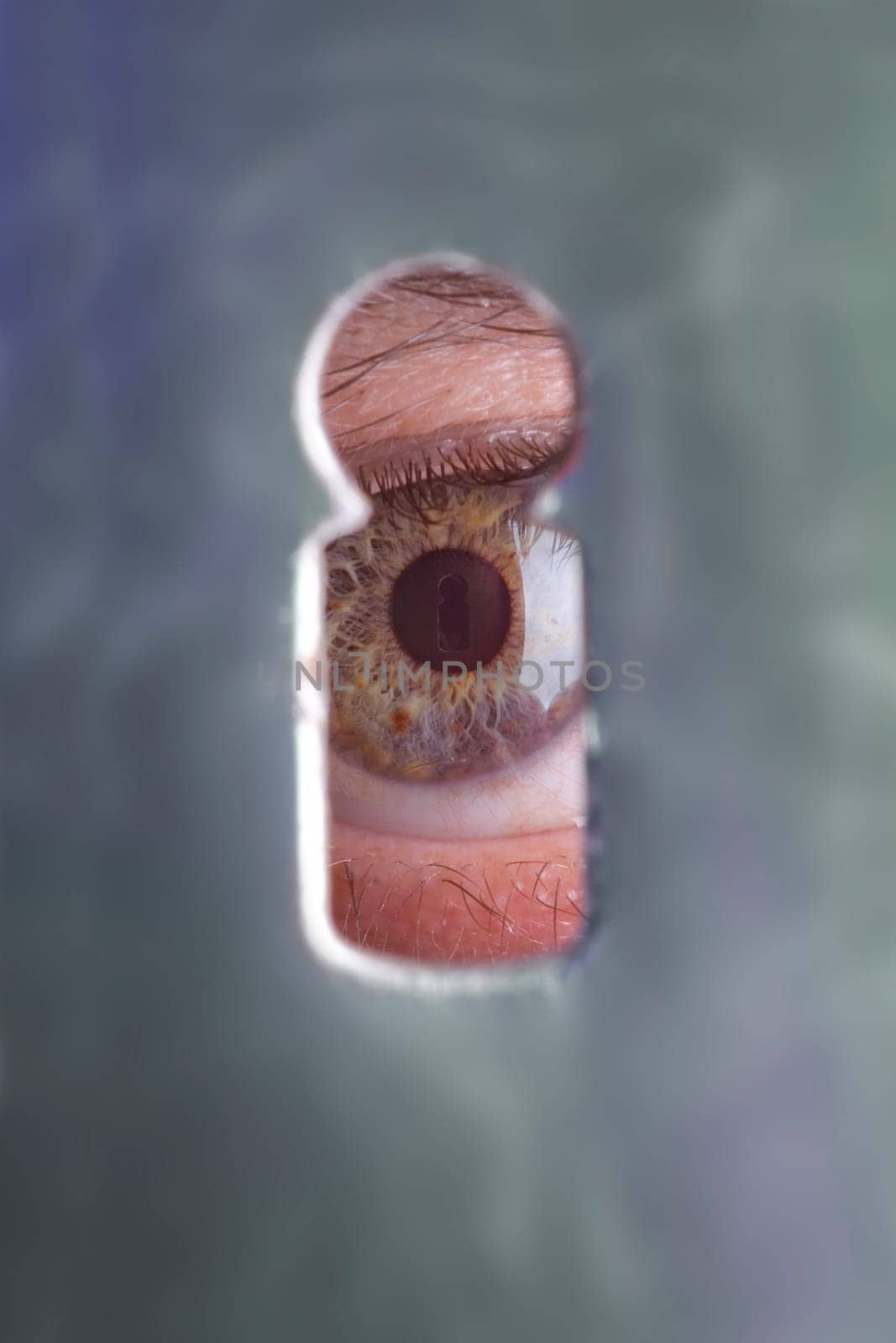 Eyes through a keyhole where the keyhole is reflected again in the pupil