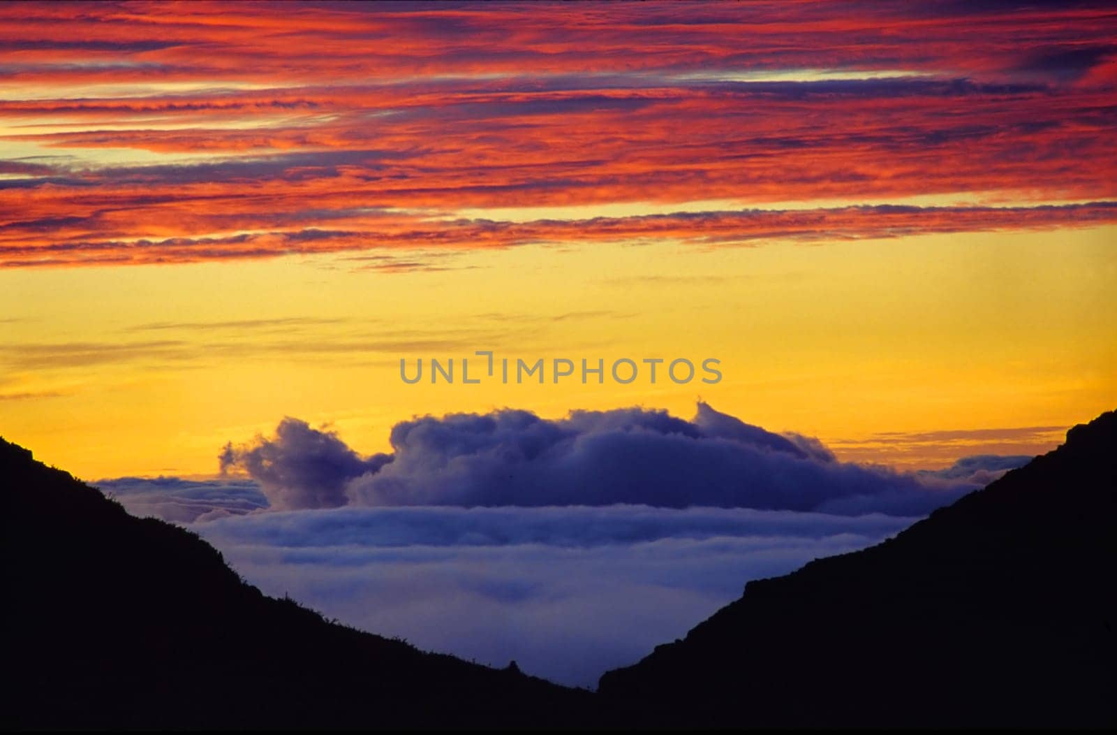 On the left hand side appear the last 60 meters to the summit of the highest elevation in Costa Rica - the Cerro Chirripó (3820m). Between the thighs of the two mountain slopes,the view opens up at dawn to a dense sea of clouds,over the expanse of the