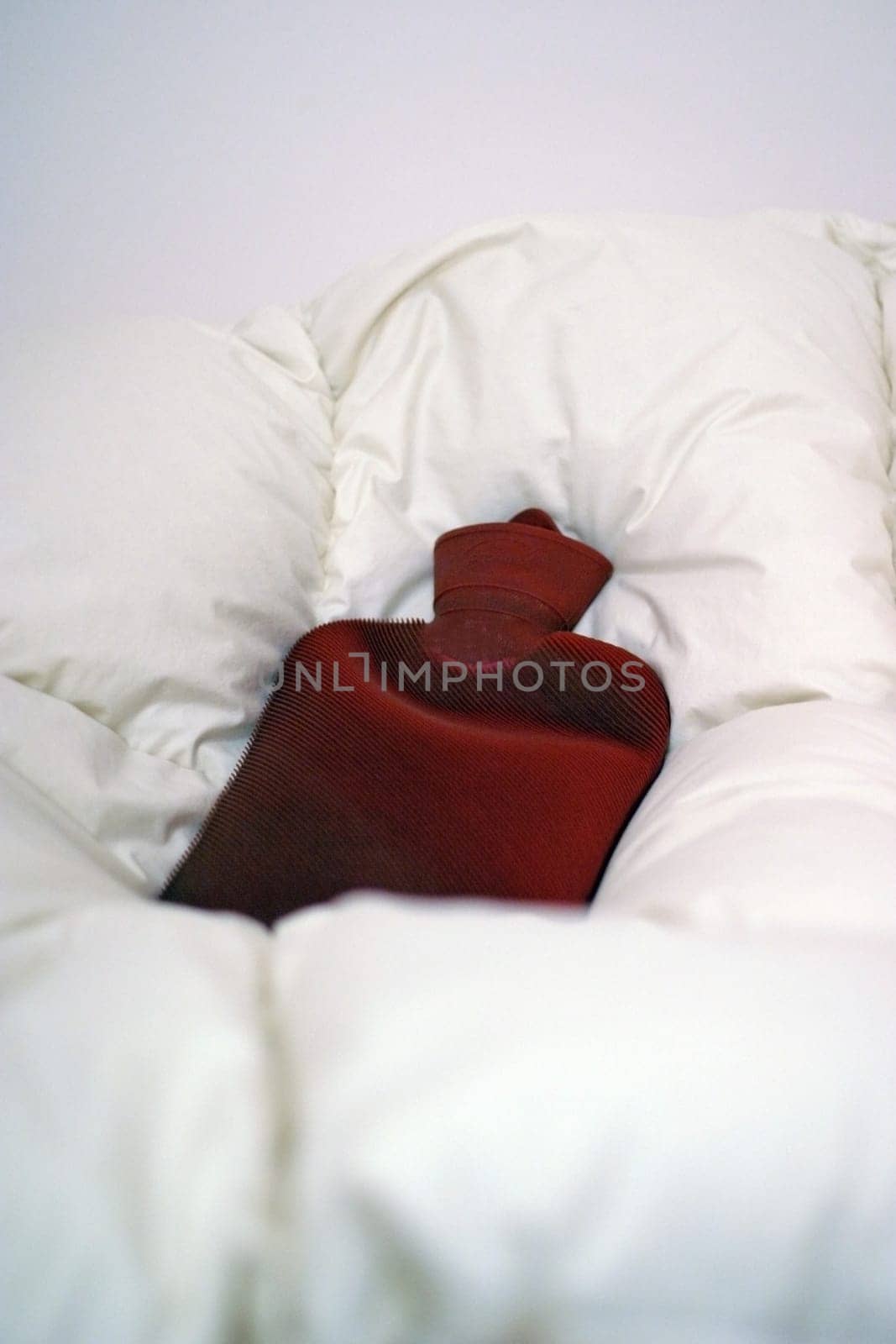 Red hot water bottle on pillow