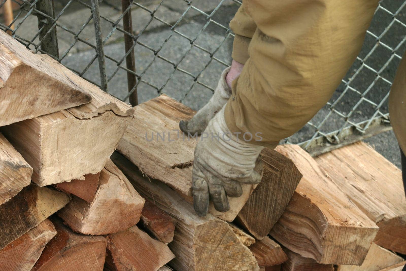 Construction of a wooden fin - close-up of hands in work gloves with logs