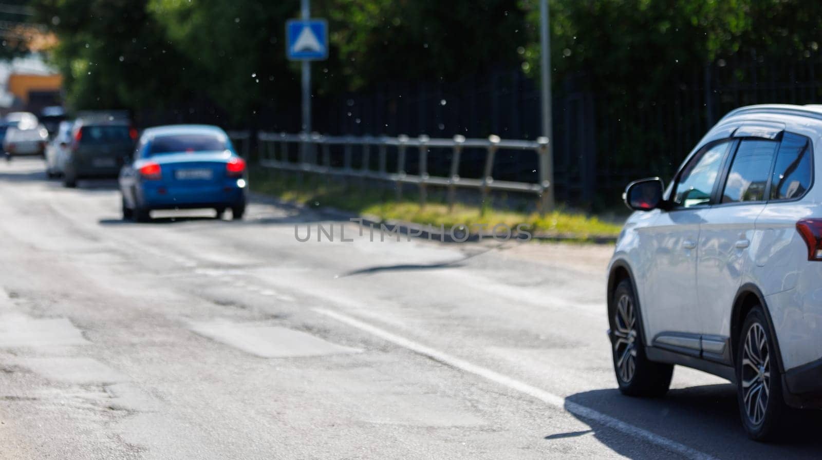 Poplar fluff in the air over country road with some cars by z1b