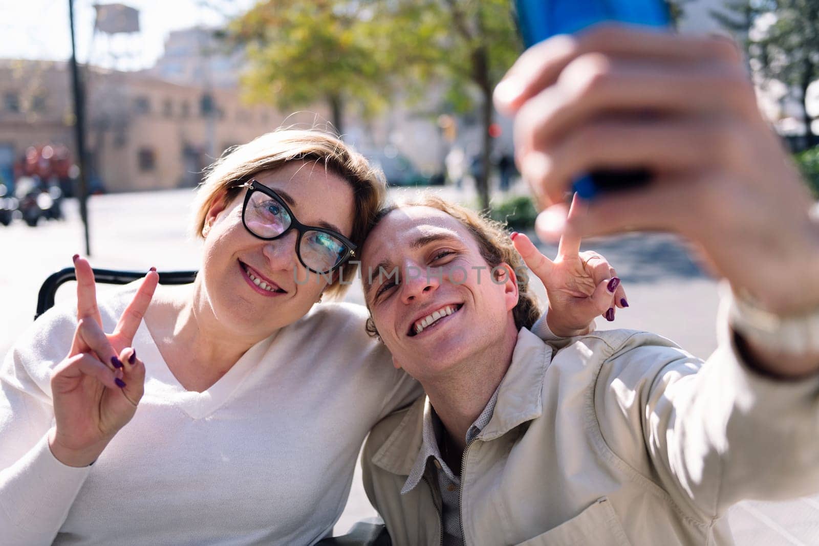 happy couple of a man and woman using wheelchair taking a selfie photo with mobile phone, concept of friendship and technology of communication