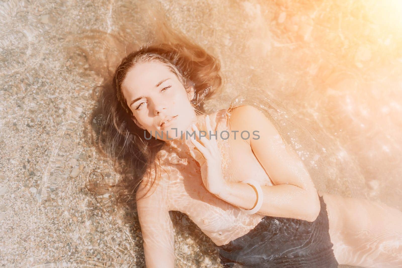 Woman summer travel sea. Happy tourist enjoy taking picture outdoors for memories. Woman traveler posing on the beach at sea surrounded by volcanic mountains, sharing travel adventure journey by panophotograph