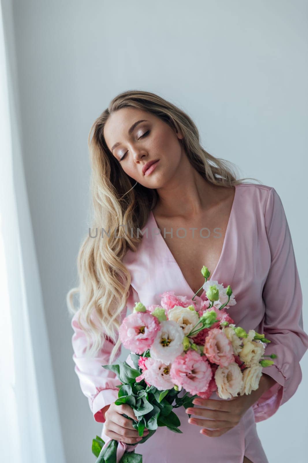 woman in pink dress with flowers in the room for a holiday