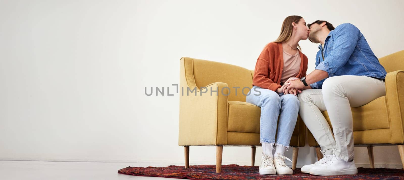 Couple on a couch, kiss and love with marriage, relationship and mockup space moment, romantic and trust. People on a sofa, man and woman with connection, care and dating with commitment and relax.