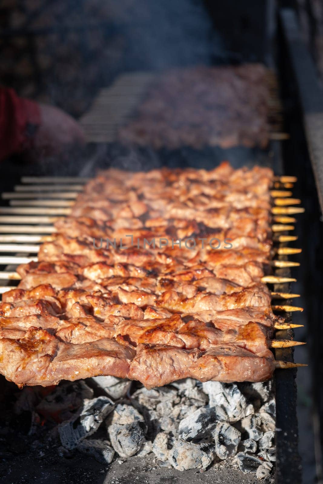 Meat pieces strung on metal skewers on the grill at sunset by AnatoliiFoto