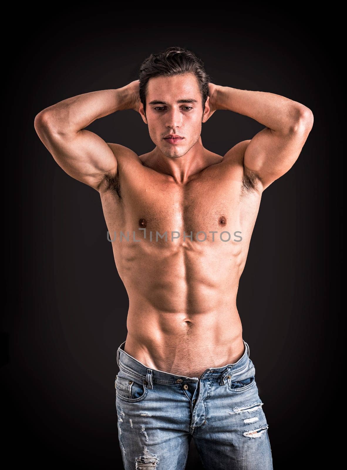 A shirtless man with hands on his head. Photo of a shirtless man with hands touching his hair