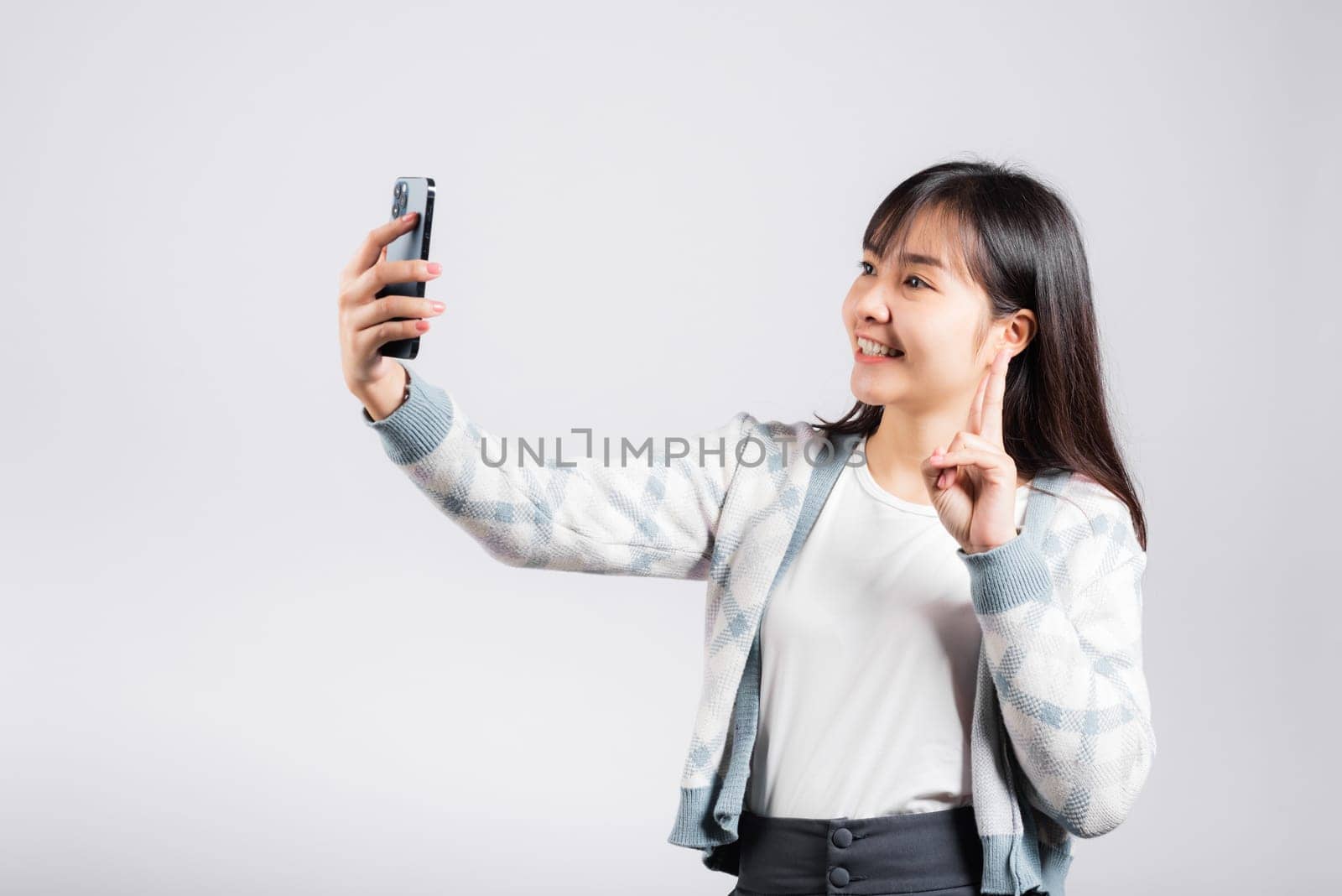 Woman excited holding smartphone to shooting selfie photo front camera by Sorapop