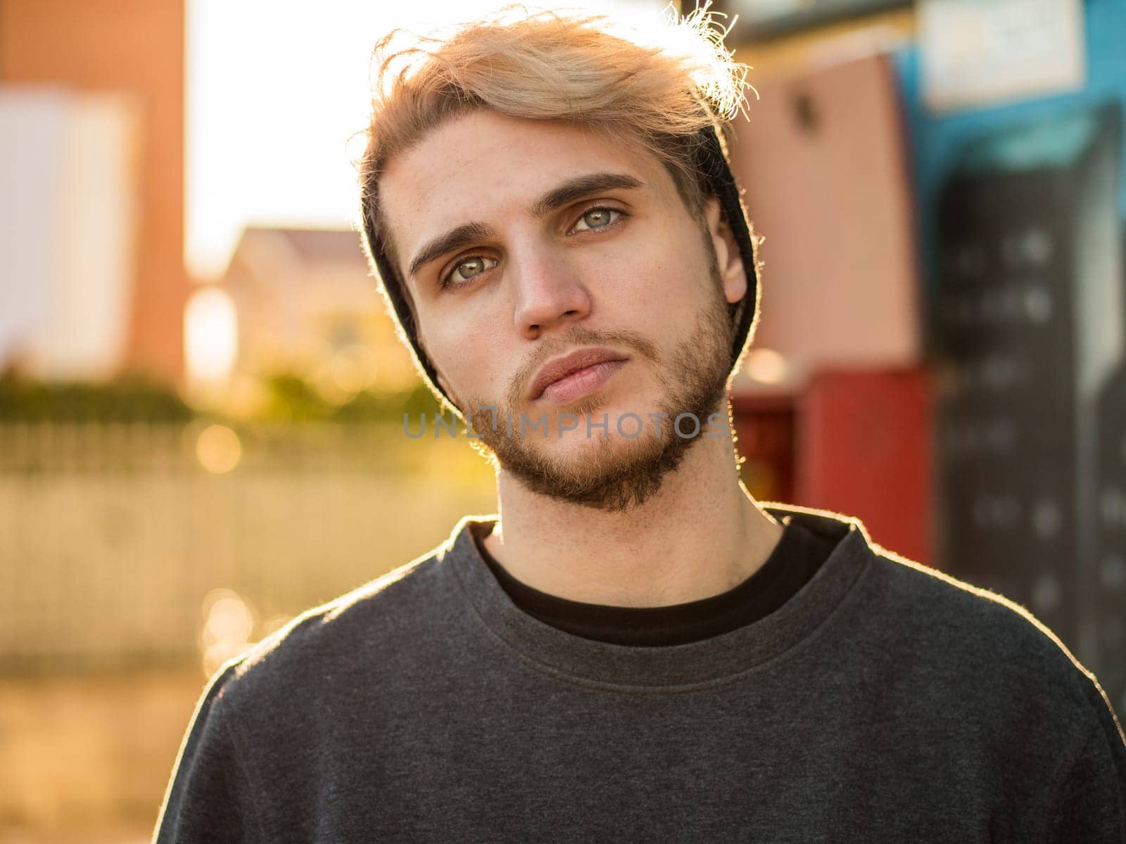 A young handsome man with a beard and a black shirt. Photo of a bearded man in a black shirt