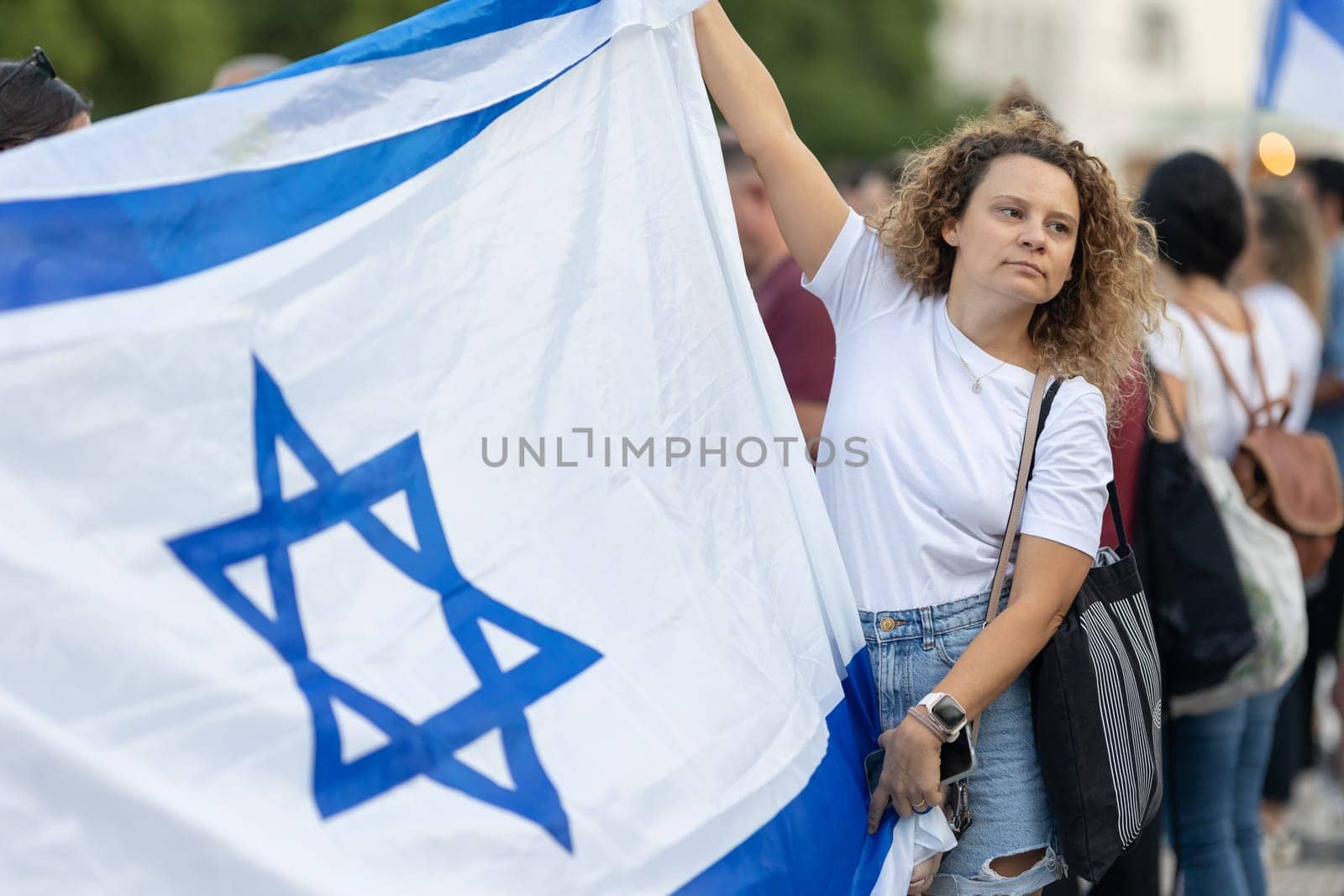 Lisbon, Portugal, October 10, 2023, A woman at a rally in support of Israel, in her hands is a flag of Israel. Mid. shot