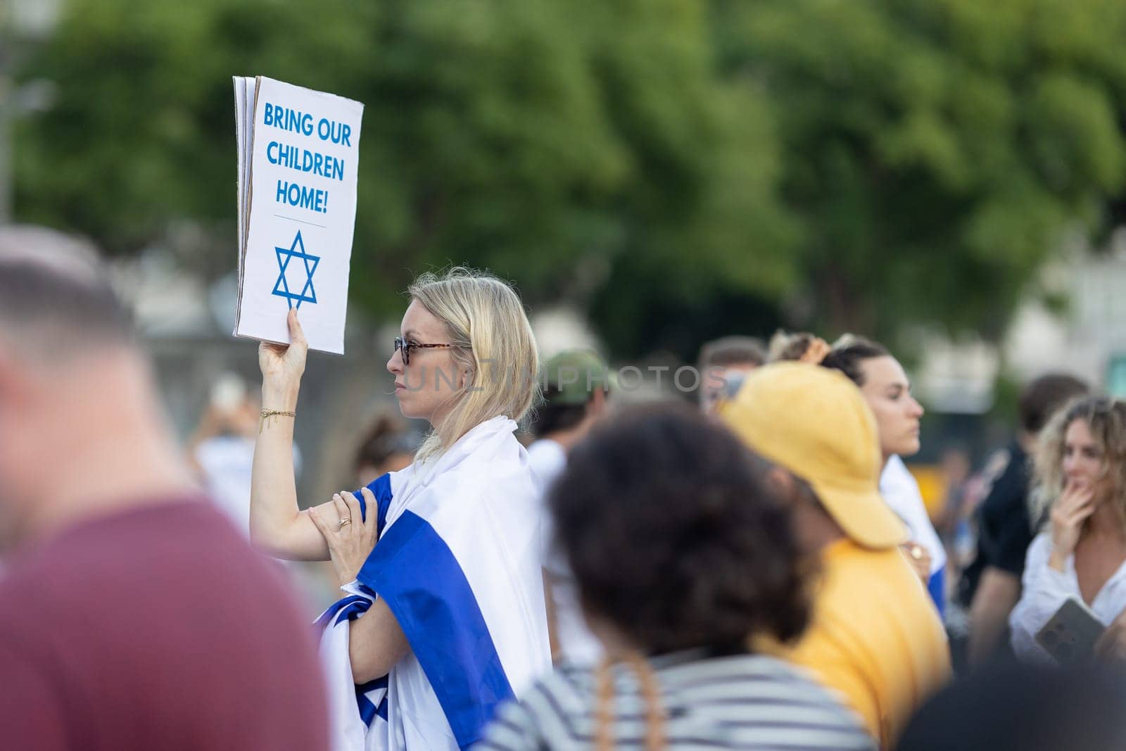 Lisbon, Portugal – October 10, 2023: A woman at a rally in support of Israel, in her hands is a poster "Bring our children home". Mid. shot