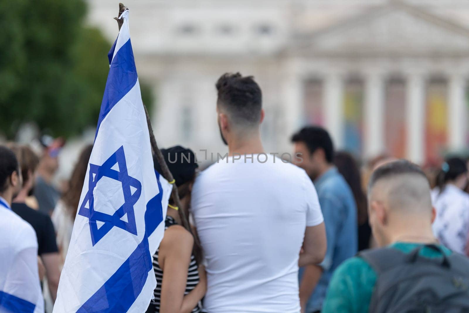 Lisbon, Portugal October 10, 2023. People at a rally in support of Israel hug and hold Israeli flags. Mid. shot