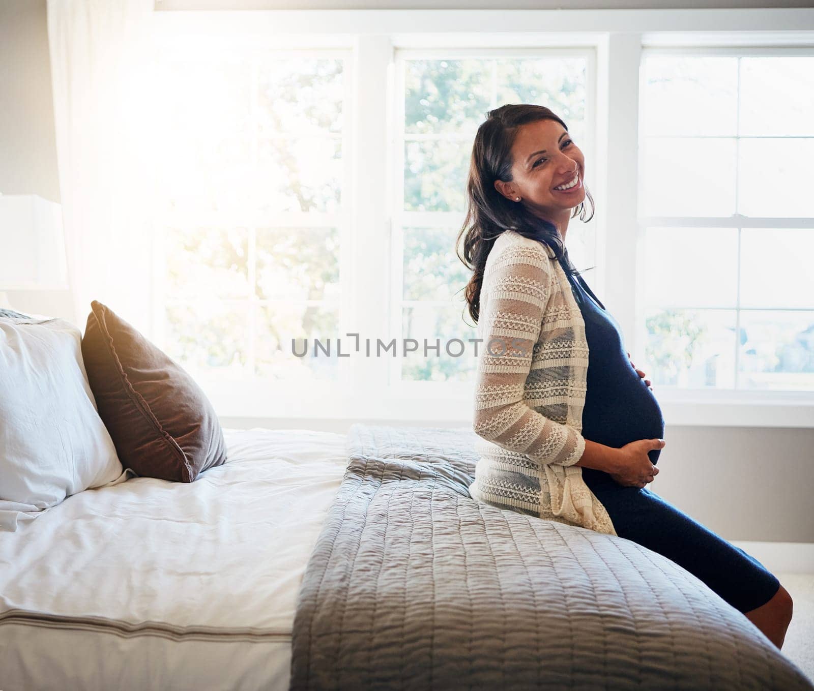 Home bed, happiness and woman pregnancy, massage stomach and mom happy for baby support, development or care. Expectation, bedroom flare and pregnant mother smile, love and relax on maternity leave.