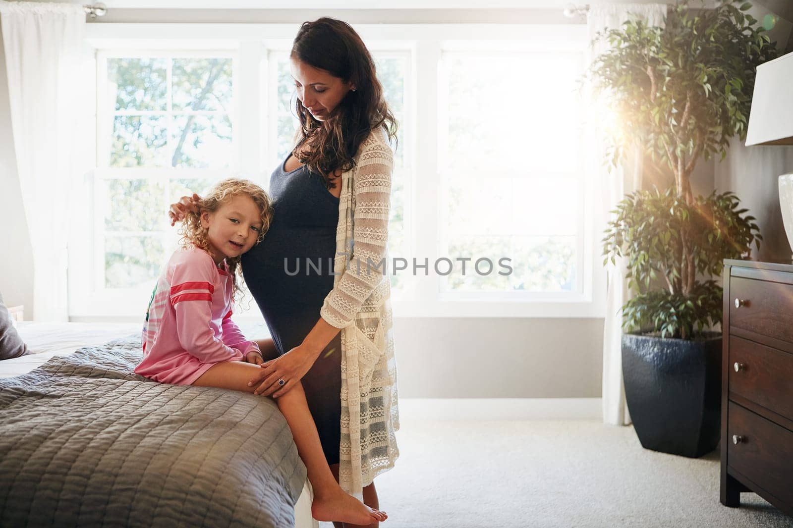 Bed, pregnant woman and kid listen to stomach, abdomen or girl hearing heartbeat, moving baby or family development. Mom, home bedroom and young child curious over pregnancy, maternity or life growth.