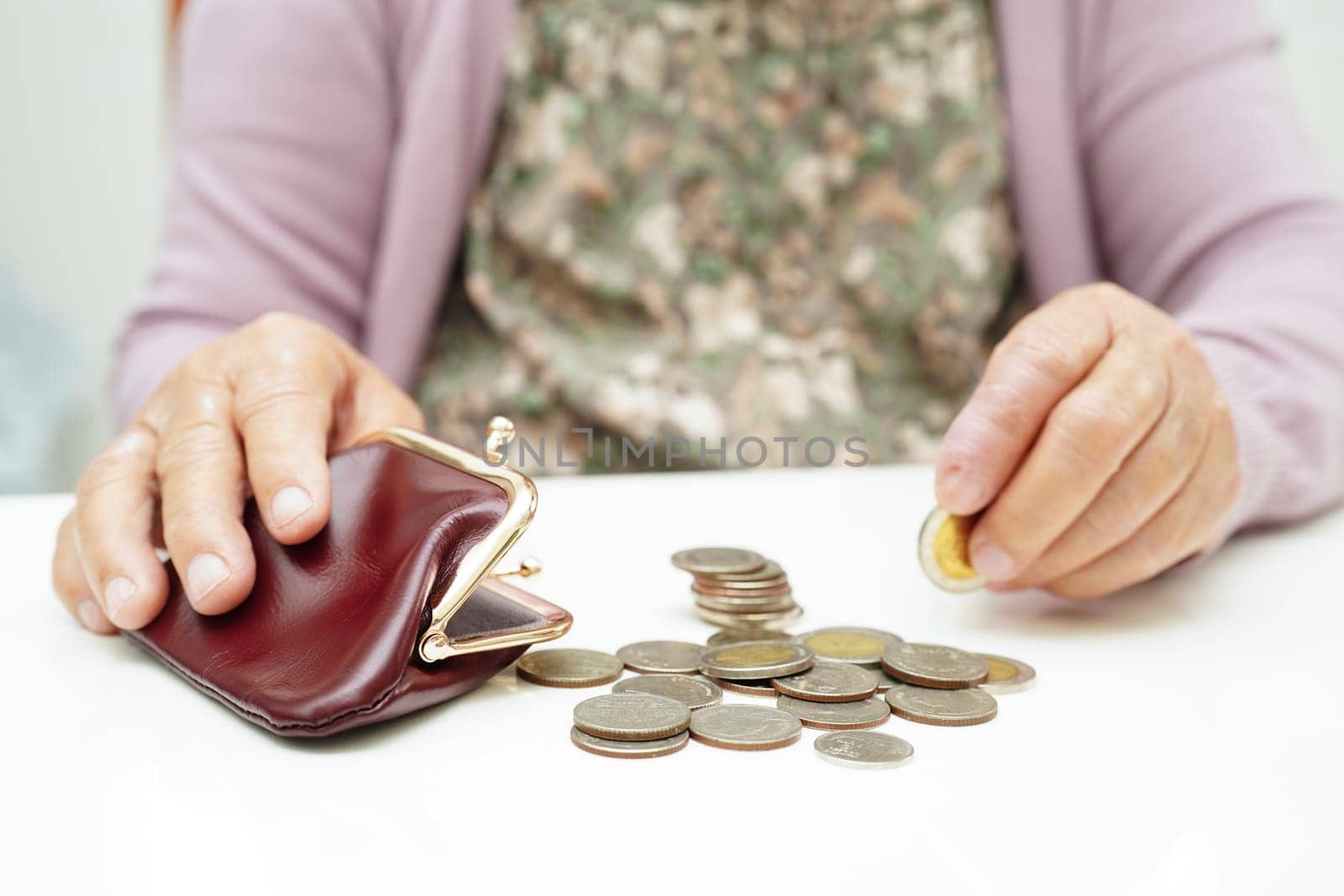 Retired elderly woman counting coins money and worry about monthly expenses and treatment fee payment.