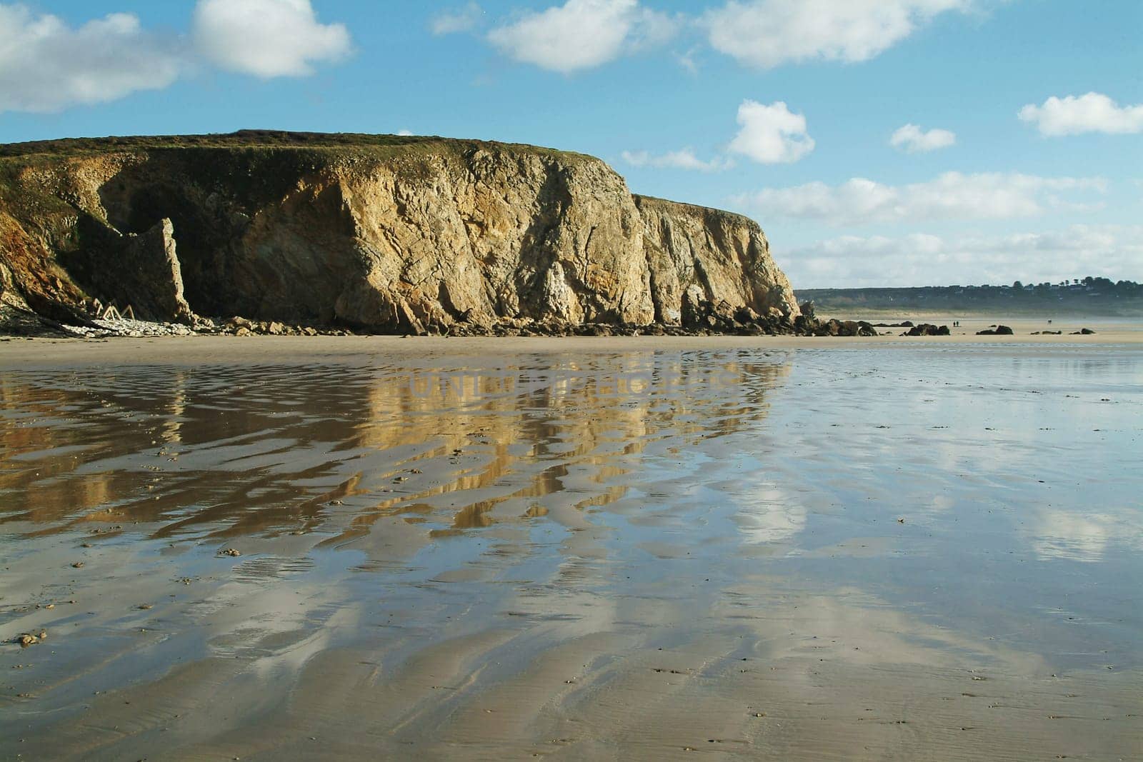 Reflecting water on a sandy beach in Brittany,France.