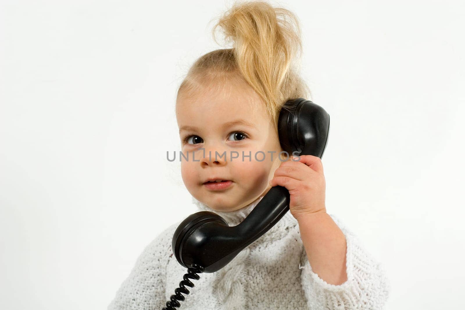 Small child talking on the phone with an old phone