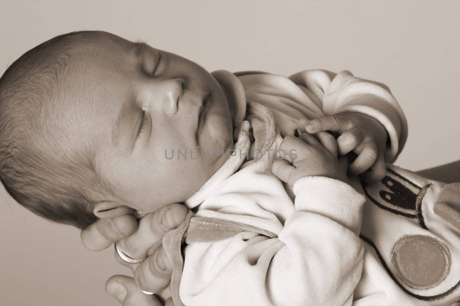 Photo shows a sleeping baby on the mother's hand