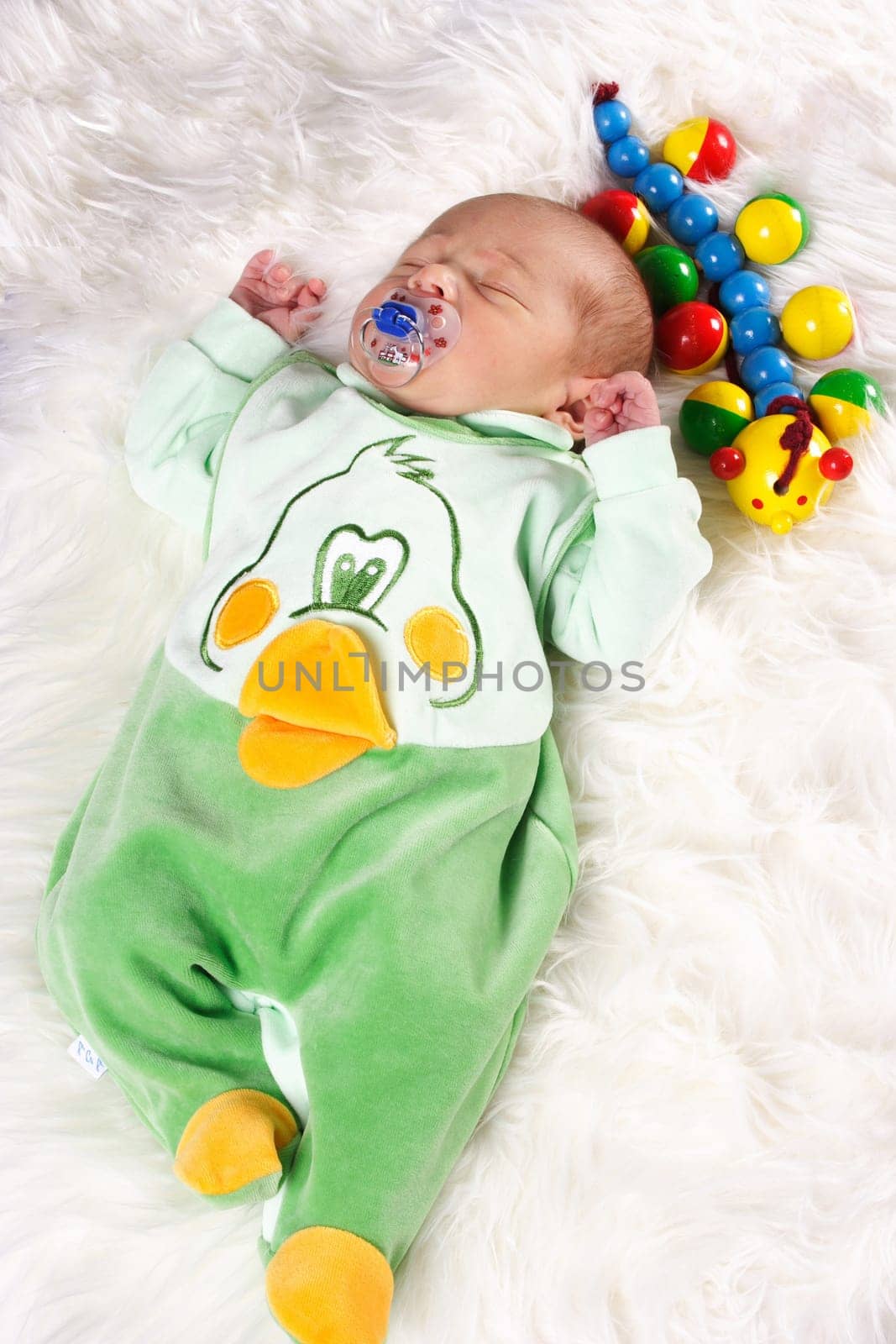 Photos shows a sleeping baby with wooden toys