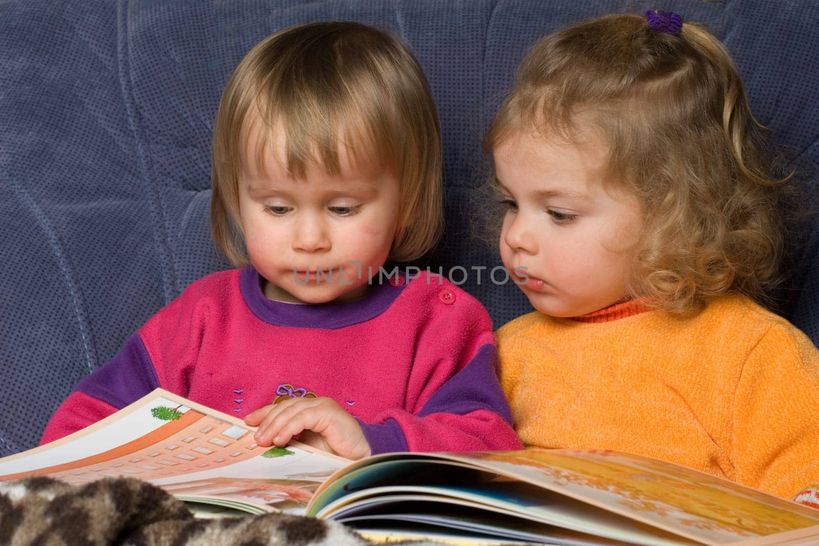 two children reading in a book