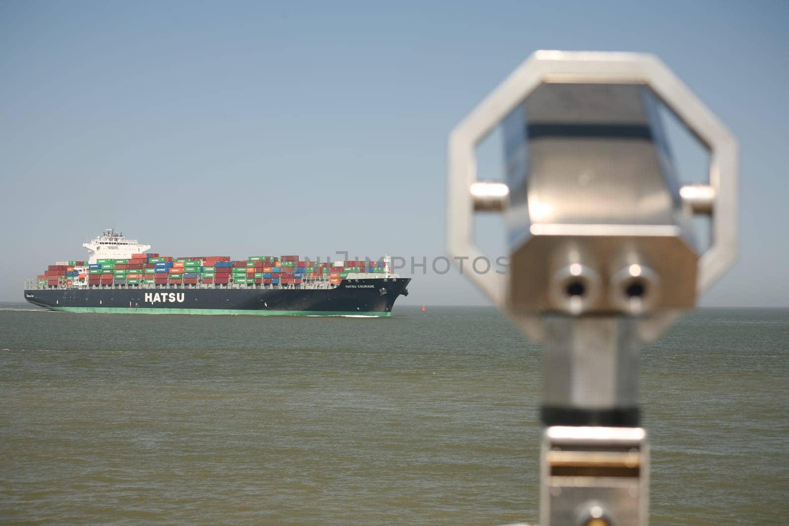 A large container ship passes the viewpoint at the Alte Liebe in Cuxhaven