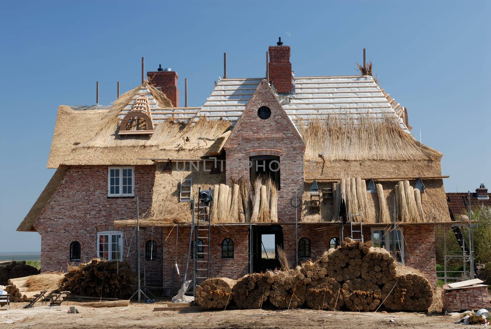 A North German house with a thatched roof is built