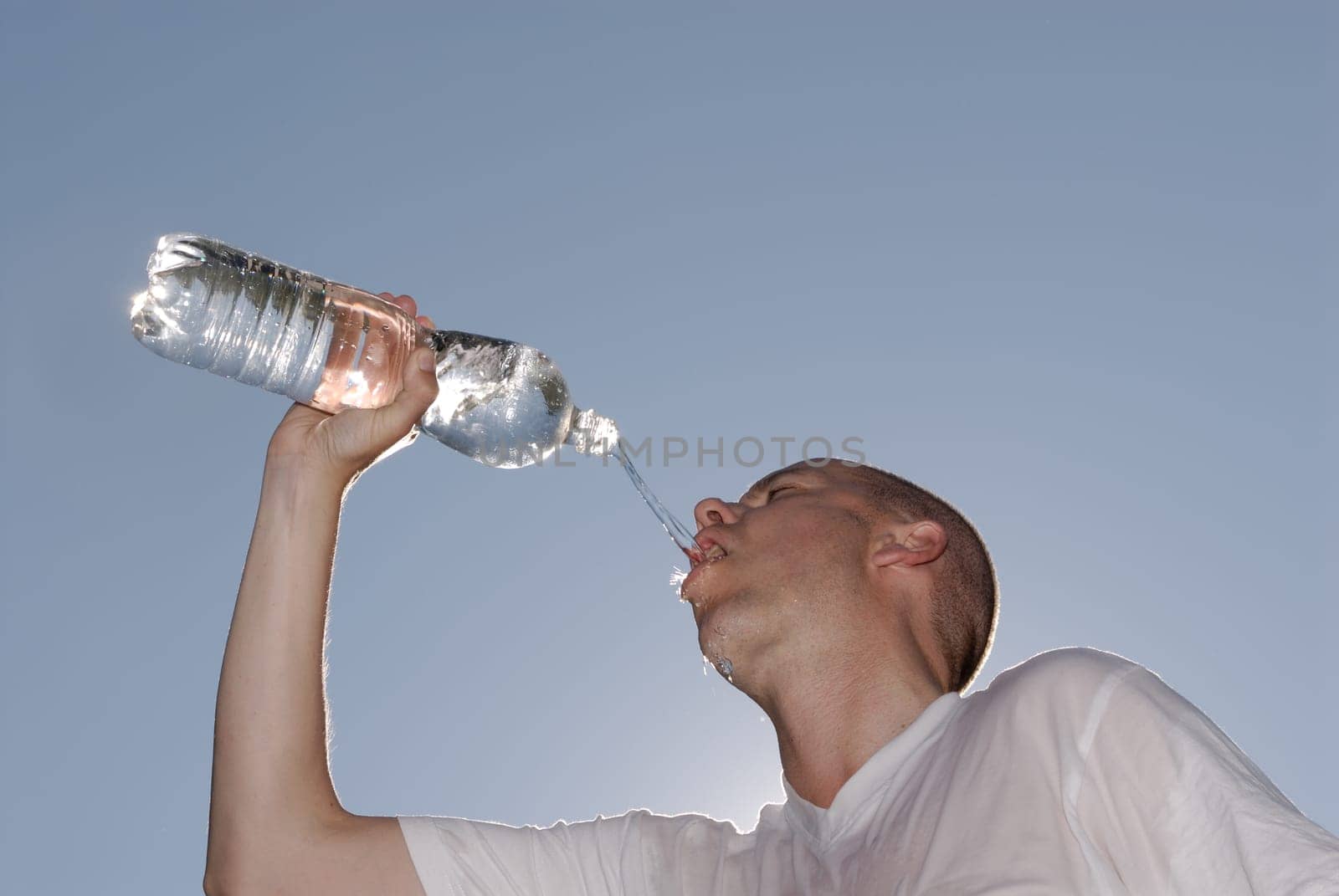 Juner man drinking from a bottle of water