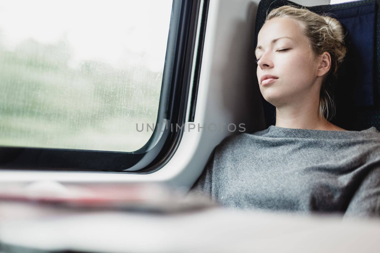 Lady traveling napping on a train. by kasto