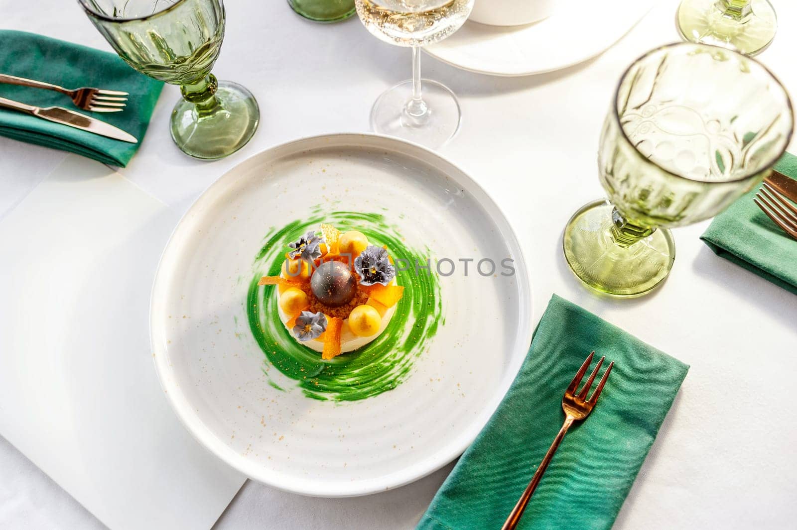 Gourmet dessert with mango meringue on a white plate on a table in a restaurant