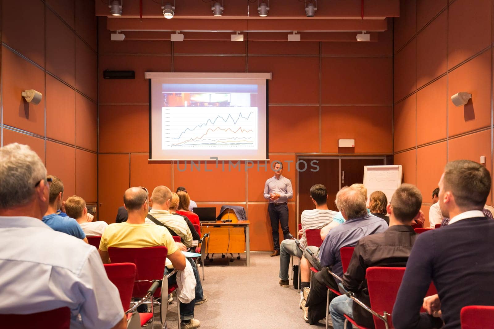 Speaker giving a talk in conference hall at business event. Unrecognizable people in audience at conference hall. Business and Entrepreneurship concept.