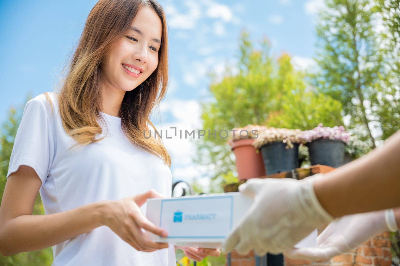 Sick Asian young woman receive medicine first aid pharmacy box from hospital delivery service by Sorapop
