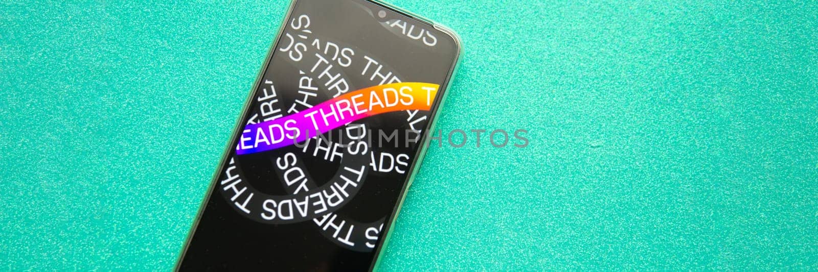 Tver, Russia - July 15, 2023, threads logo on the smartphone screen, on a green background. The threads icon. The logo of the current application. Threads social network