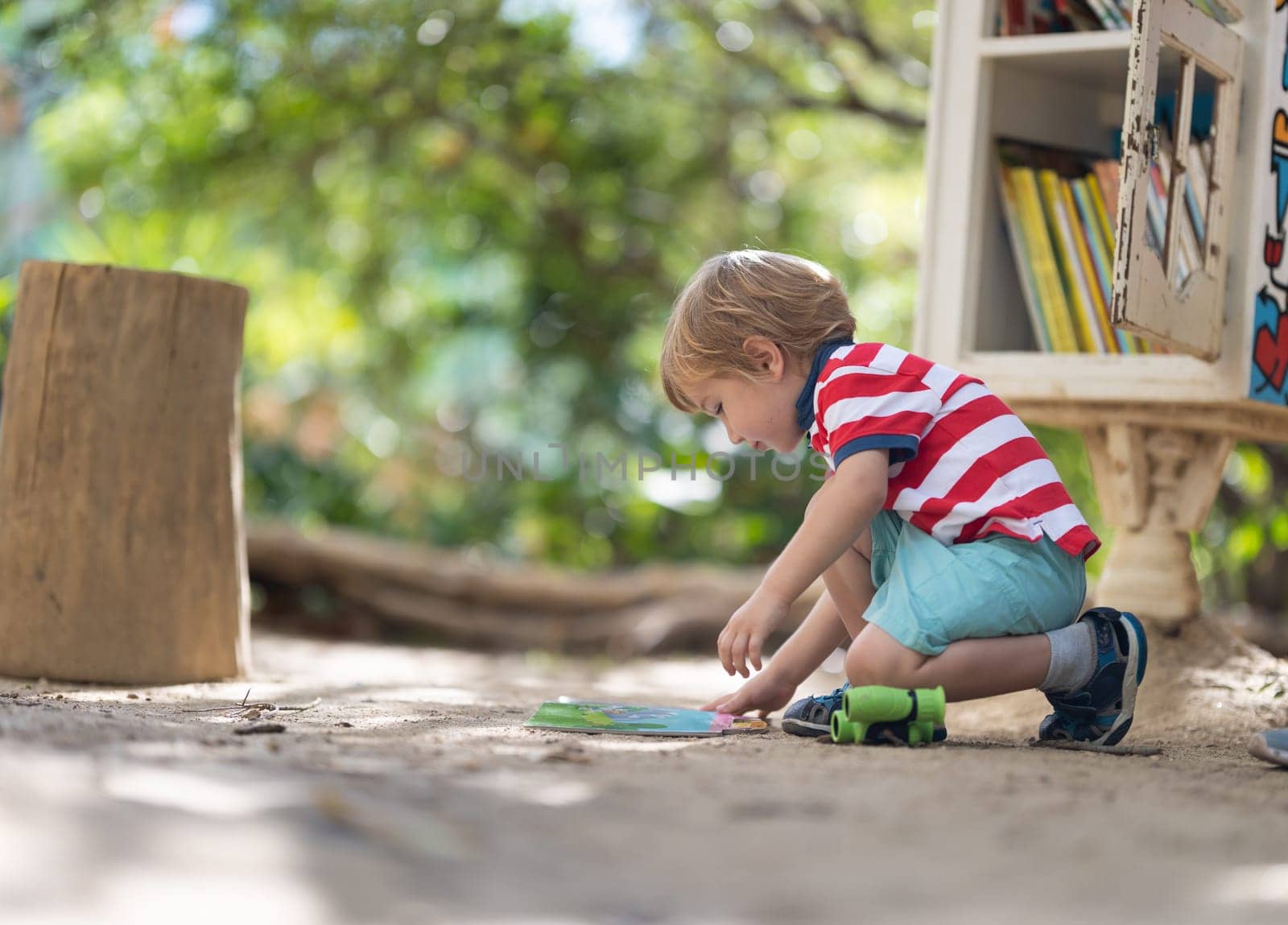 Cute little blonde boy playing on the playground. Mid shot