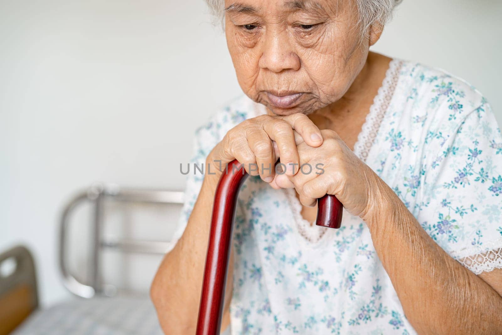 Asian elderly disability woman holding waling stick, wood cane, round handle, walking aid for help to walk. by pamai