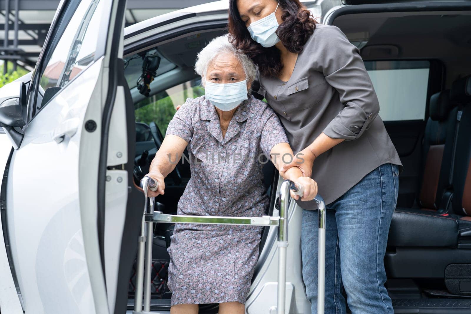 Asian senior woman patient sitting on walker prepare get to her car, healthy strong medical concept.