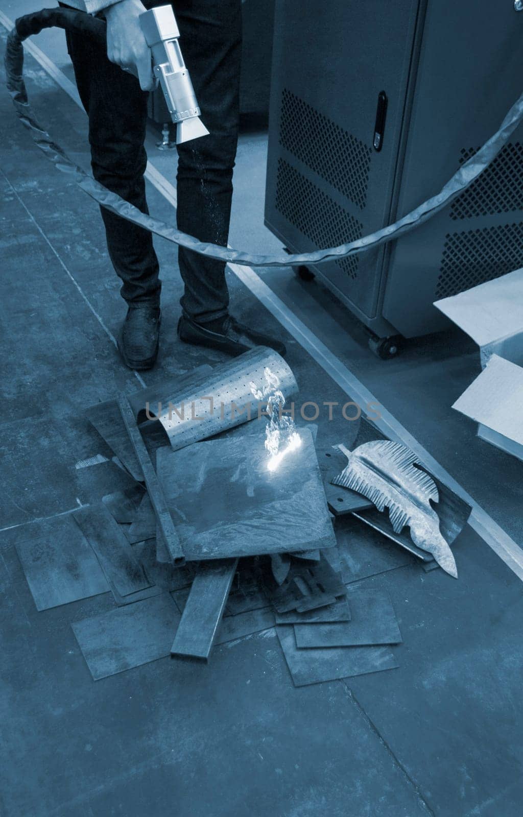 Laser metal cleaning. A man using laser metal cleaning machine to clean a metal surface from rust. Worker cleaning metal from coating by laser. Steel laser clean technologies. New modern technology