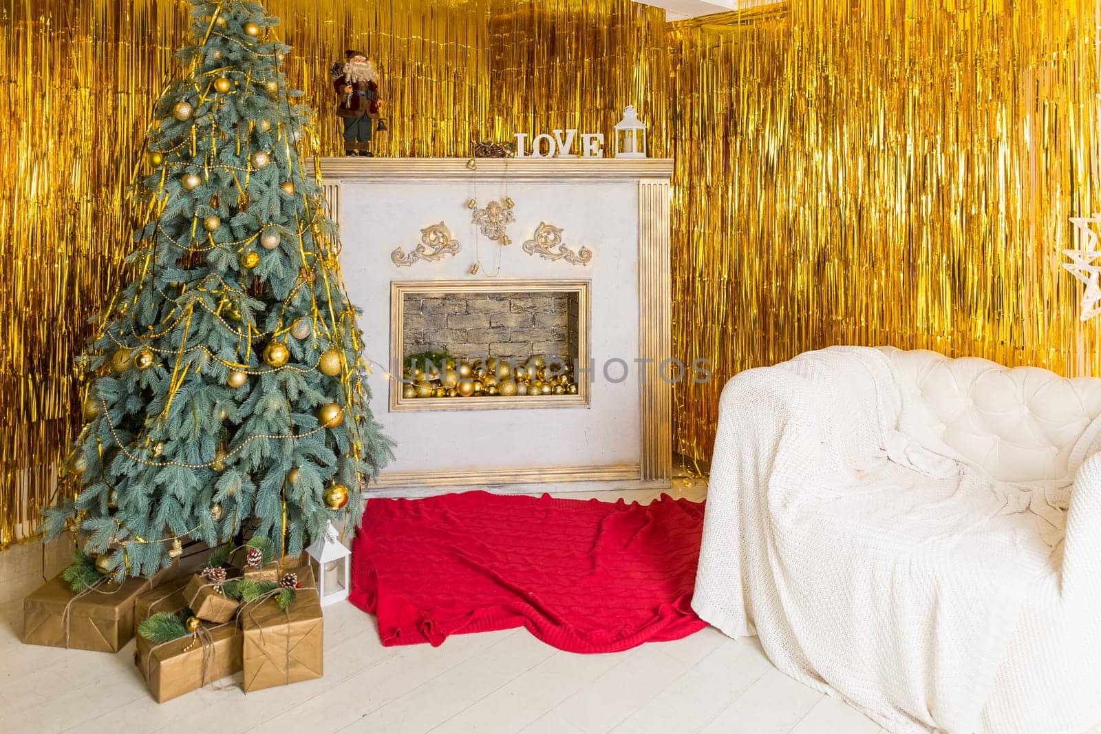 Photo of luxury gift boxes under Christmas tree, New Year home decorations, golden wrapping of Santa presents