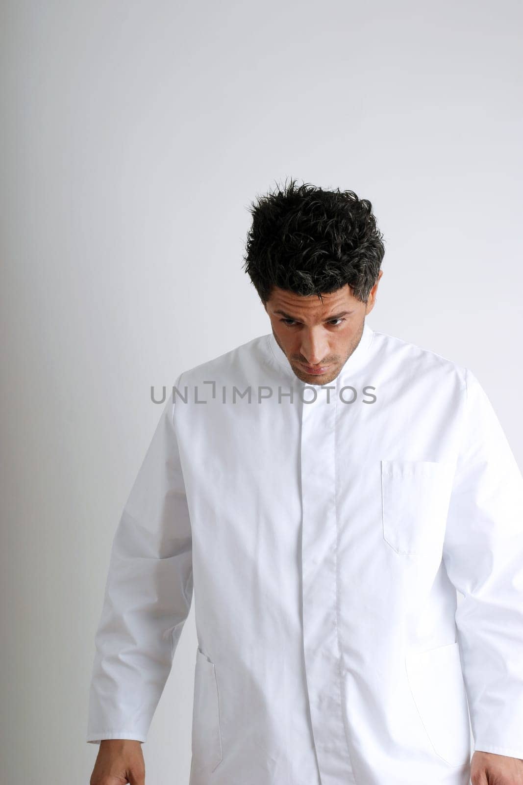 Man in white coat looking down