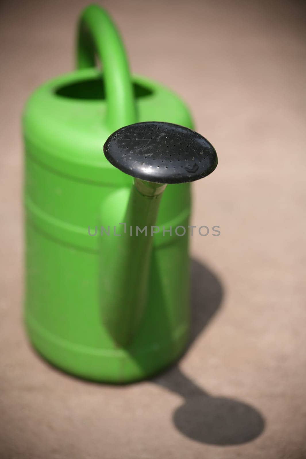 Green plastic watering can